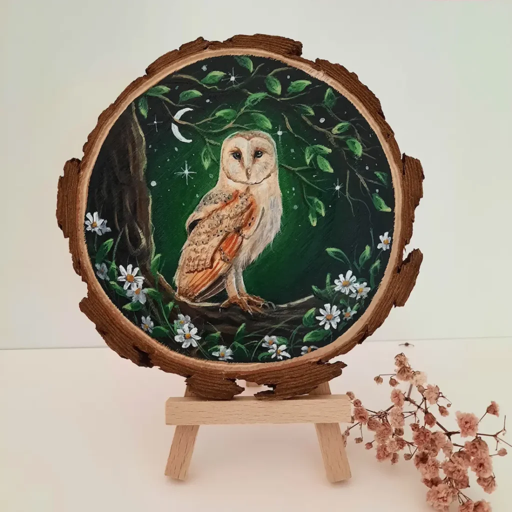 Schilderij op boomschijf van kerkuil op tak in het maanlicht