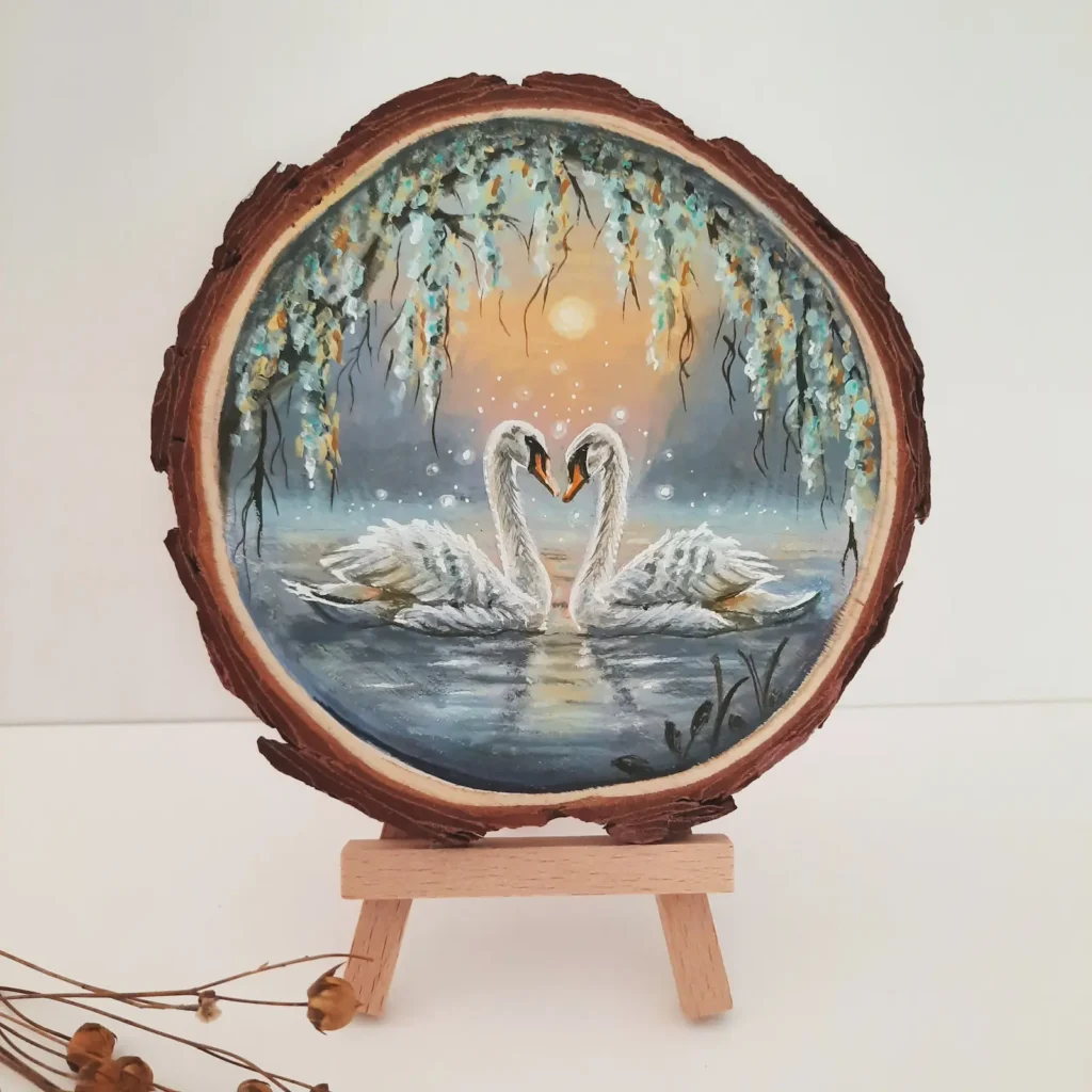 Schilderij op boomschijf van twee zwanen met een zonsondergang