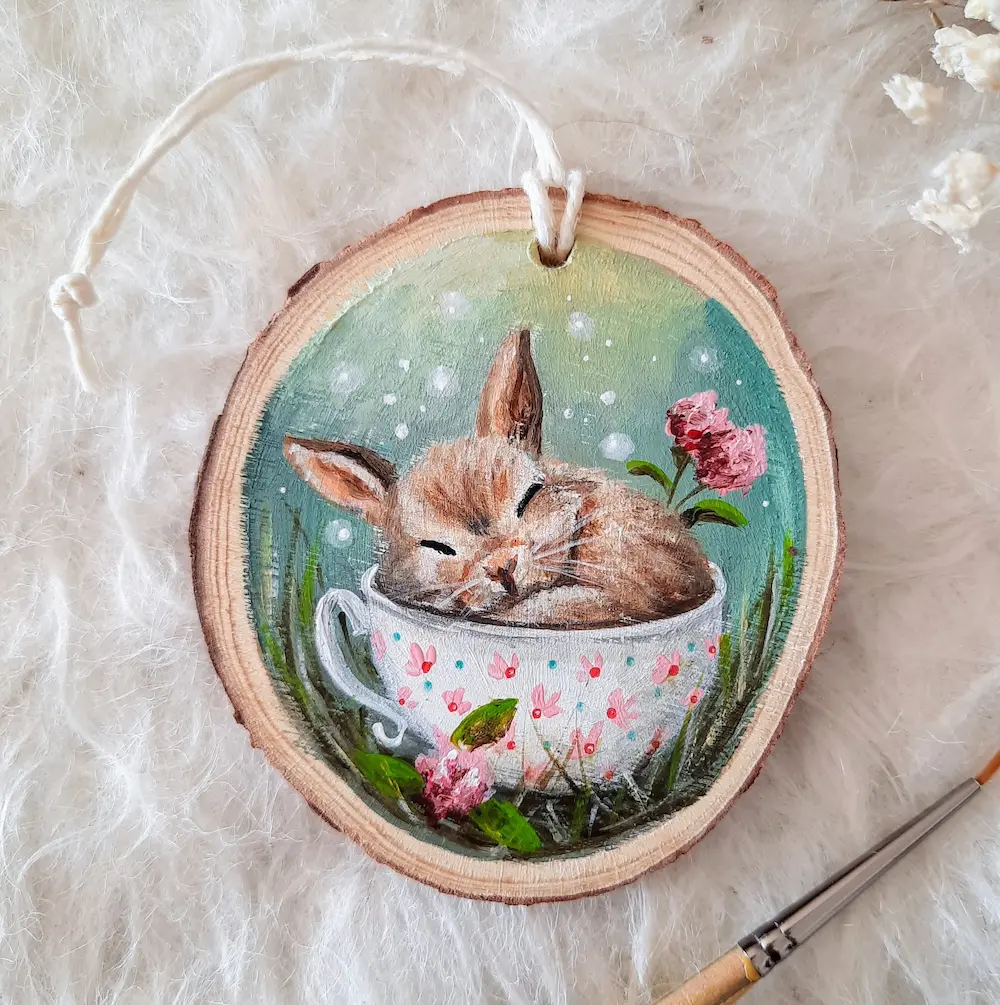 Handpainted treeslice of a sleeping bunny in a mug