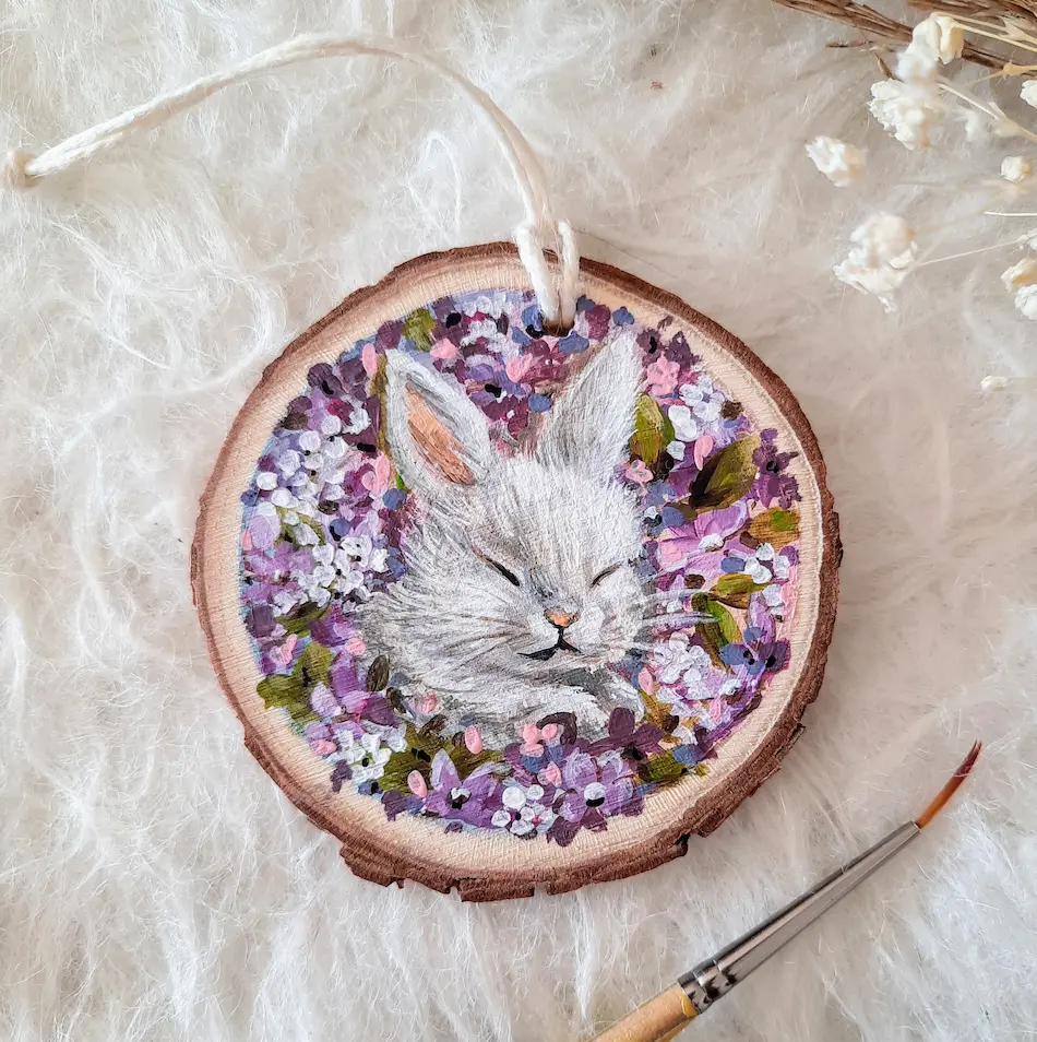 Handpainte treeslice of white bunny sleeping among the lilac