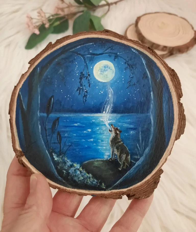 Handgeschilderde boomschijf van huilende wolf aan een blauw meer met volle maan