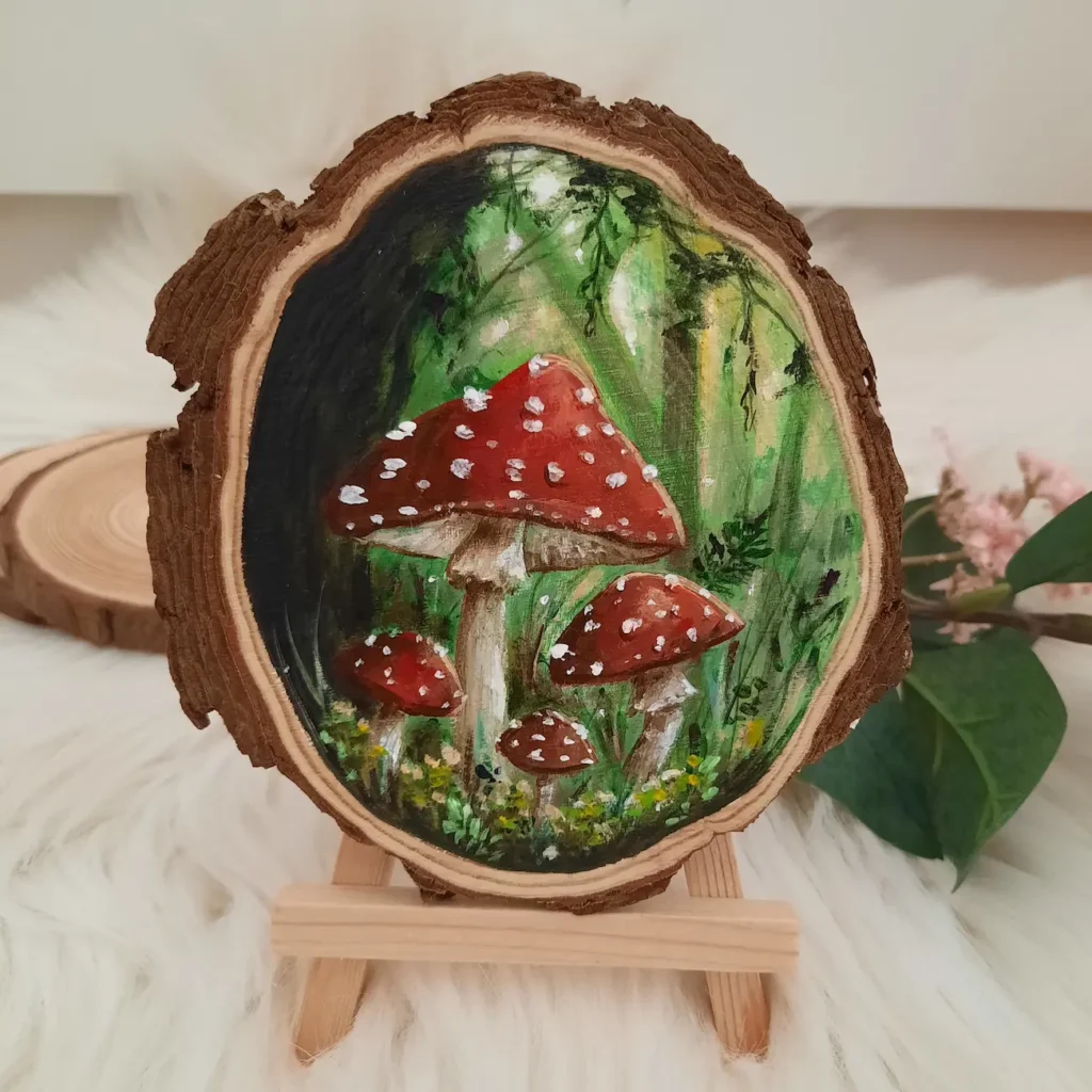 handgeschilderde boomschijf van 4 rode paddenstoelen met witte stippen in groen bos
